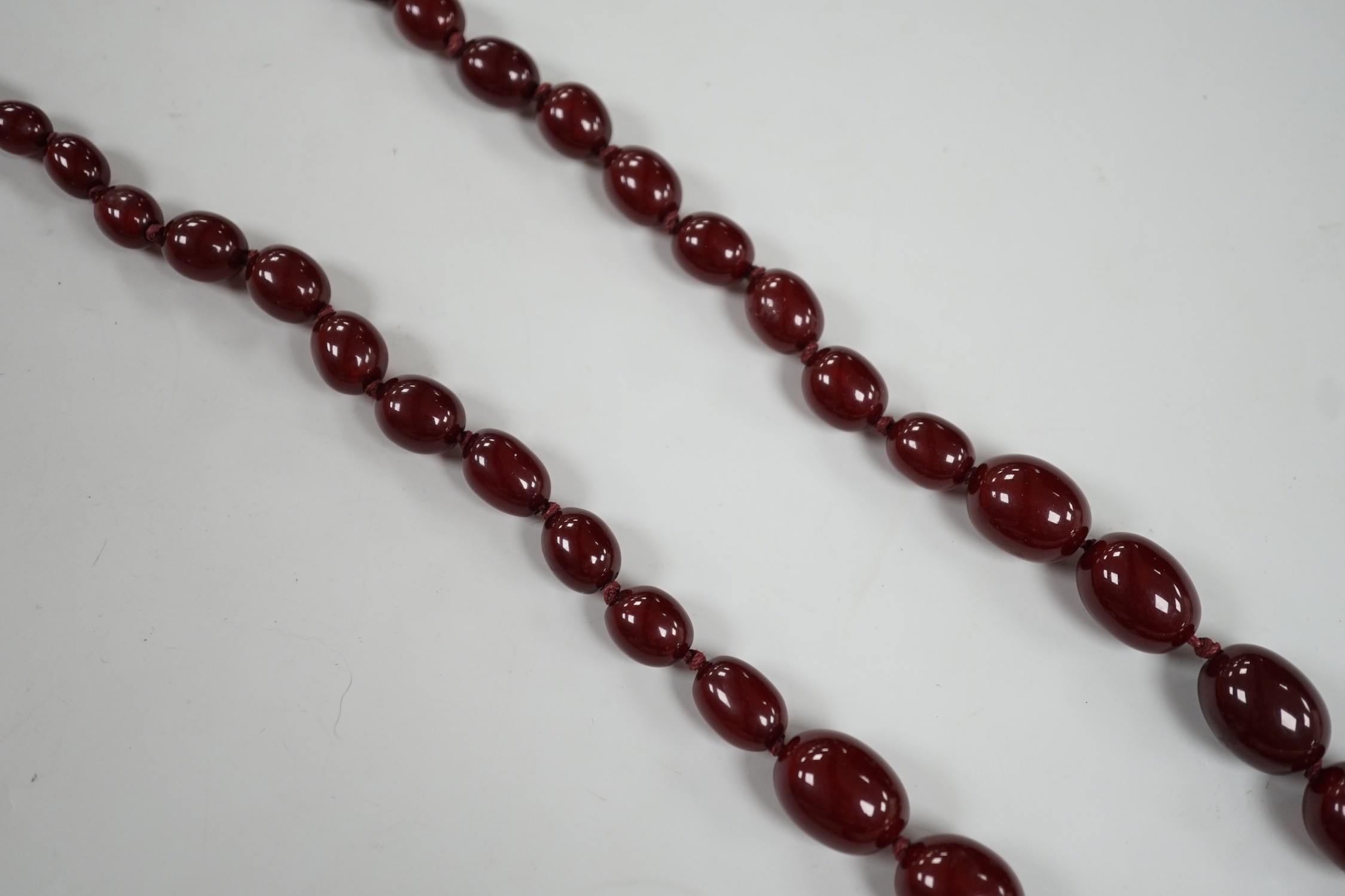 A single strand graduated simulated cherry amber necklace, 82cm, gross weight 83 grams.